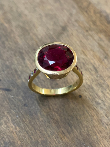 Rubelite Tourmaline Oval 5.47 carats, set in 18ct Pink Gold, with brilliant cut Diamonds, G colour, VS1 clarity weighing 0.11ct and fine brilliant cut Rubies 0.09ct, flush set in 18ct Yellow Gold. Ring size M, but can be altered. Gross weight 5.55 grams